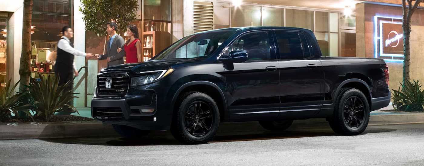 A couple hands the keys of their black 2023 Honda Ridgeline Black Edition to a valet attendant.