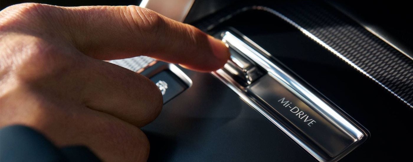 A close up shows a person touching the Mi-Drive switch in a 2024 Mazda CX 90 PHEV.