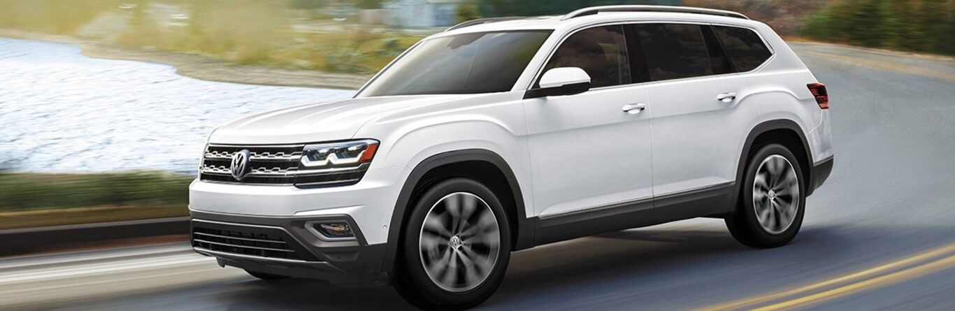 Front driver angle of a white 2020 Volkswagen Atlas driving down a road
