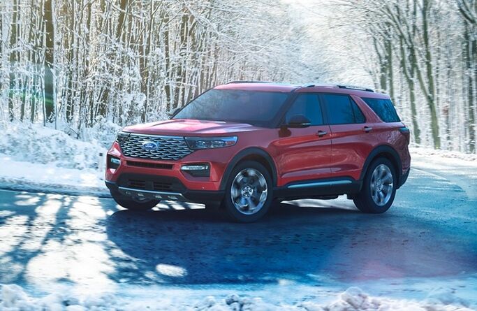 Front driver angle of a red 2020 Ford Explorer driving in the winter