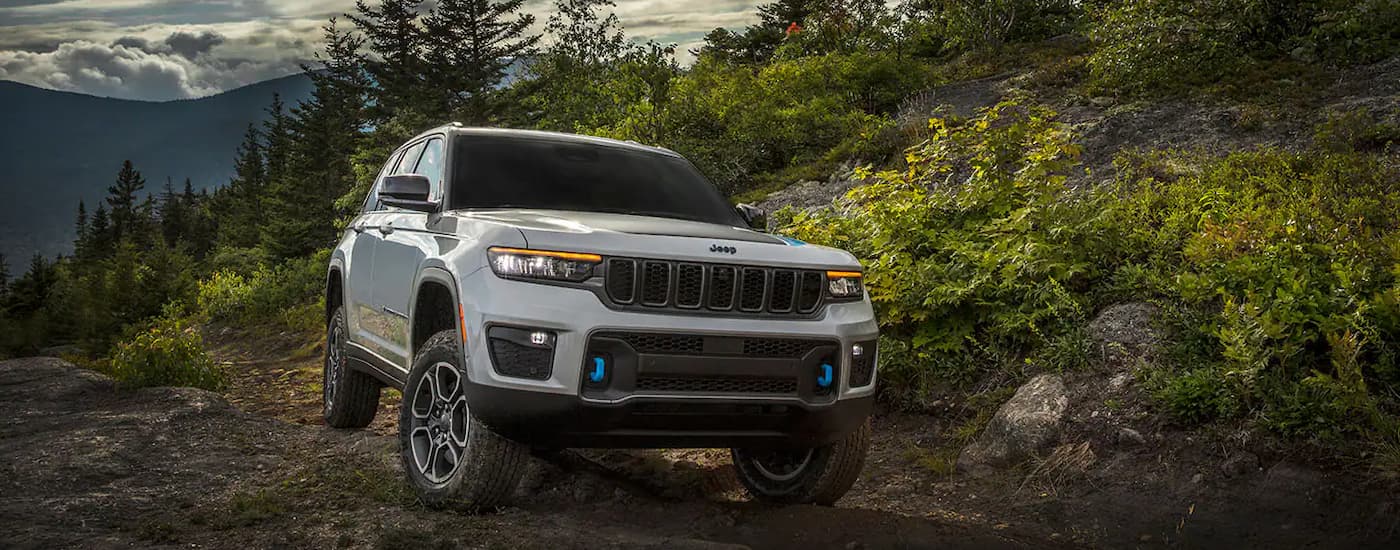A grey 2024 Jeep Grand Cherokee 4xe is shown parked on a trail after viewing EVs for sale near Fort Saskatchewan.