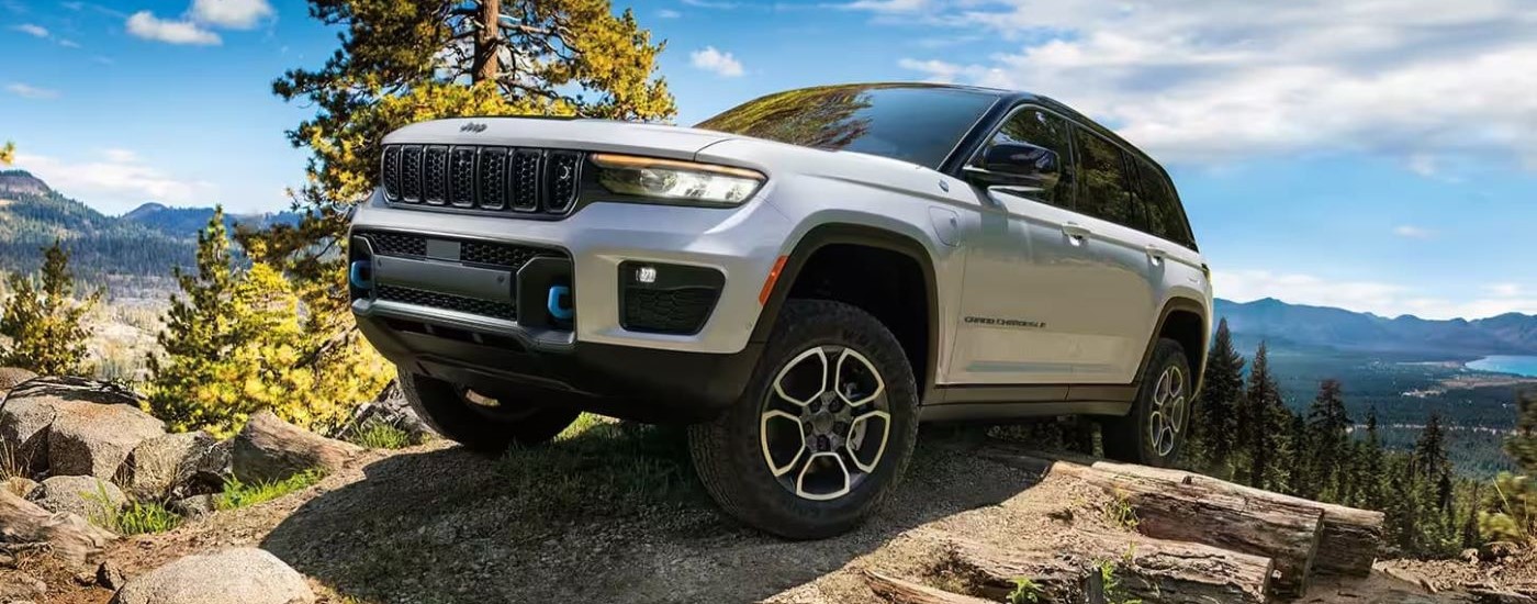 A silver  2024 Jeep Grand Cherokee 4xe is shown off-roading.