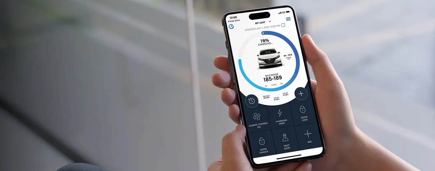 A close up of a phone shows the 2024 Nissan LEAF connectivity application for EVs for sale in Edmonton.