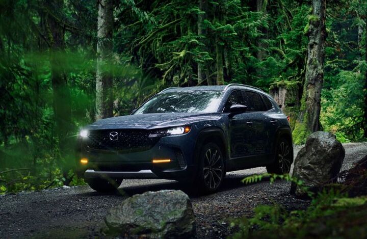 A 2023 Mazda CX-50 on a road in the woods