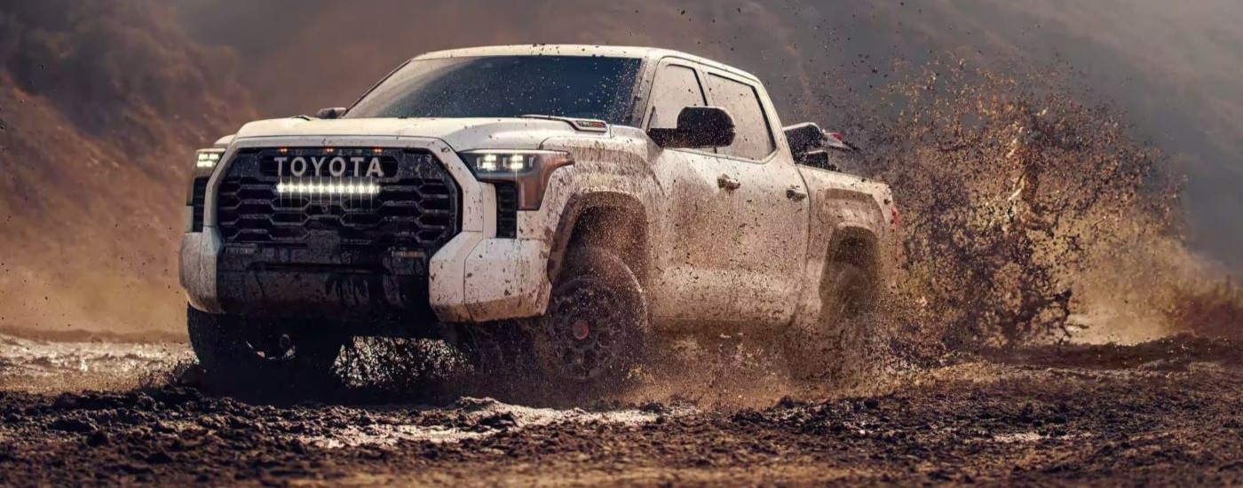 A white 2024 Toyota Tundra TRD Pro is shown kicking up mud.