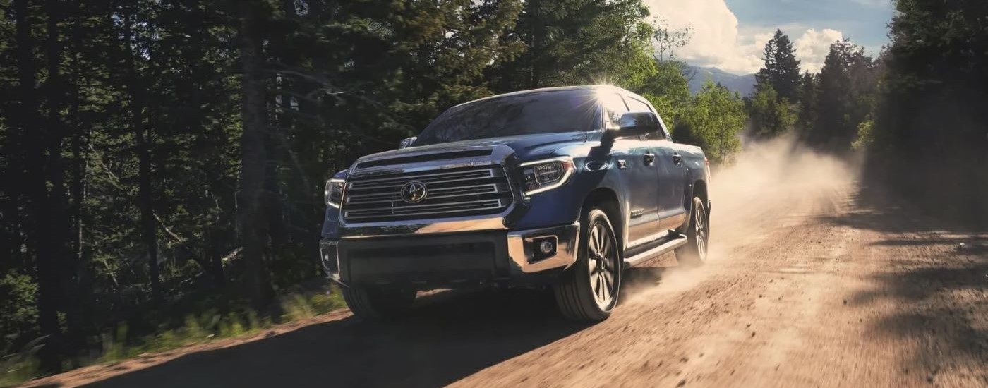 A blue 2020 Toyota Tundra is shown on a dusty trail after leaving a used Toyota dealer.