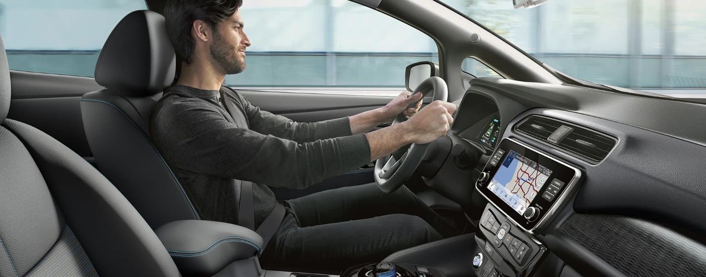 A person is shown driving a 2024 Nissan LEAF.