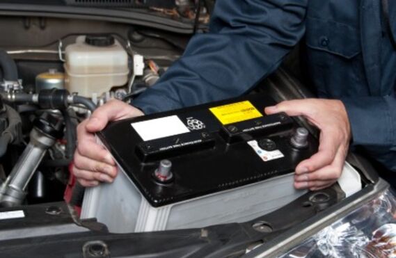 Mechanic replacing a car battery