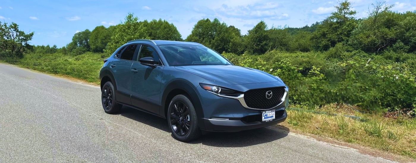 A blue 2023 Mazda CX-30 for sale is shown on an open road.