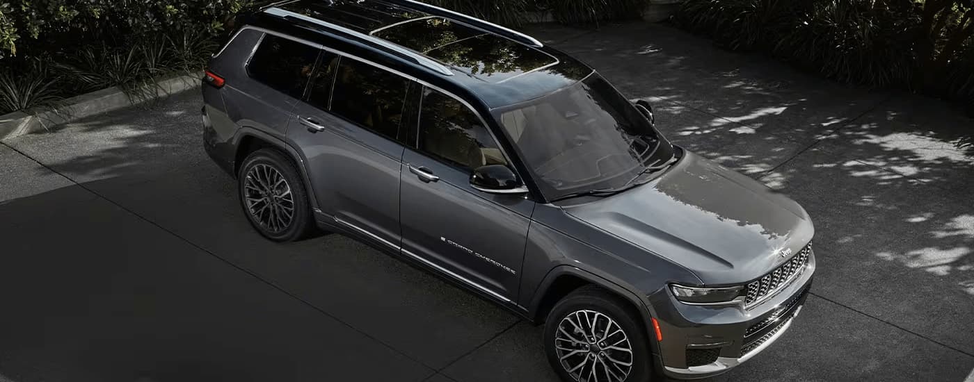A grey 2023 Jeep Grand Cherokee L, one of many popular Jeep SUVs, is shown parked in a lot.