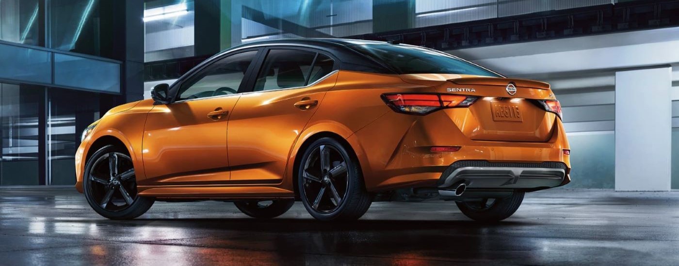 An orange 2022 Nissan Sentra for sale is shown from the side at night.