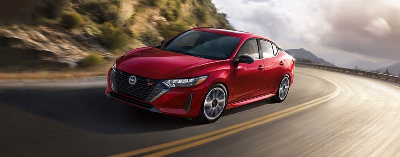 A red 2024 Nissan Sentra SR is shown rounding a corner.