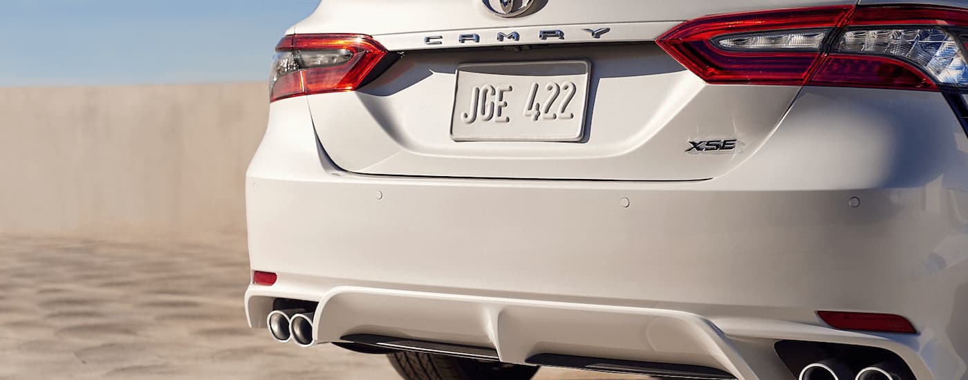 A close up of the rear bumper of a white 2024 Toyota Camry XSE V6 is shown.
