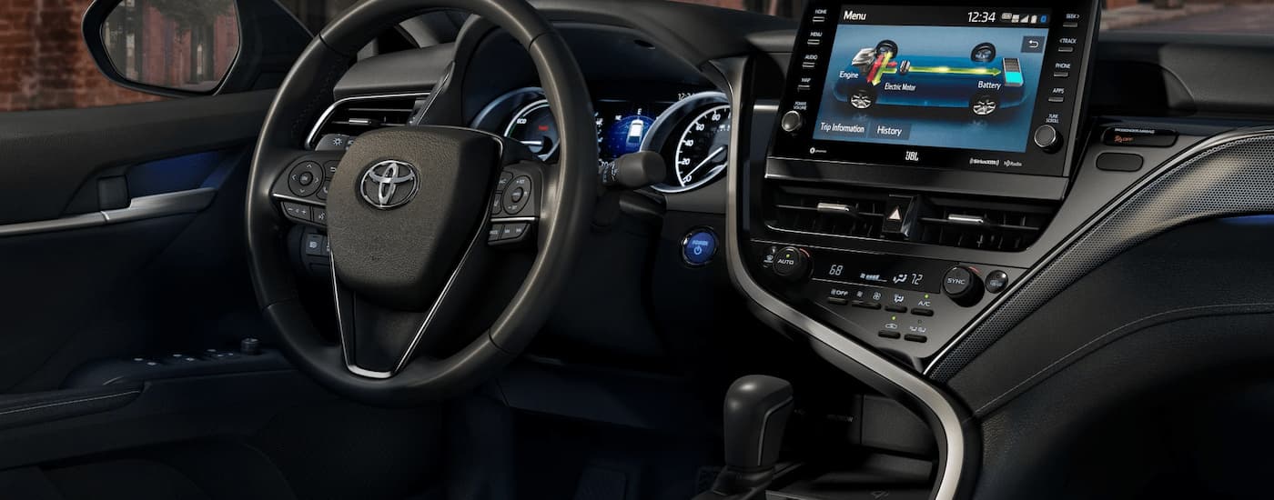 The center console and steering wheel of a 2024 Toyota Camry XSE Hybrid is shown.