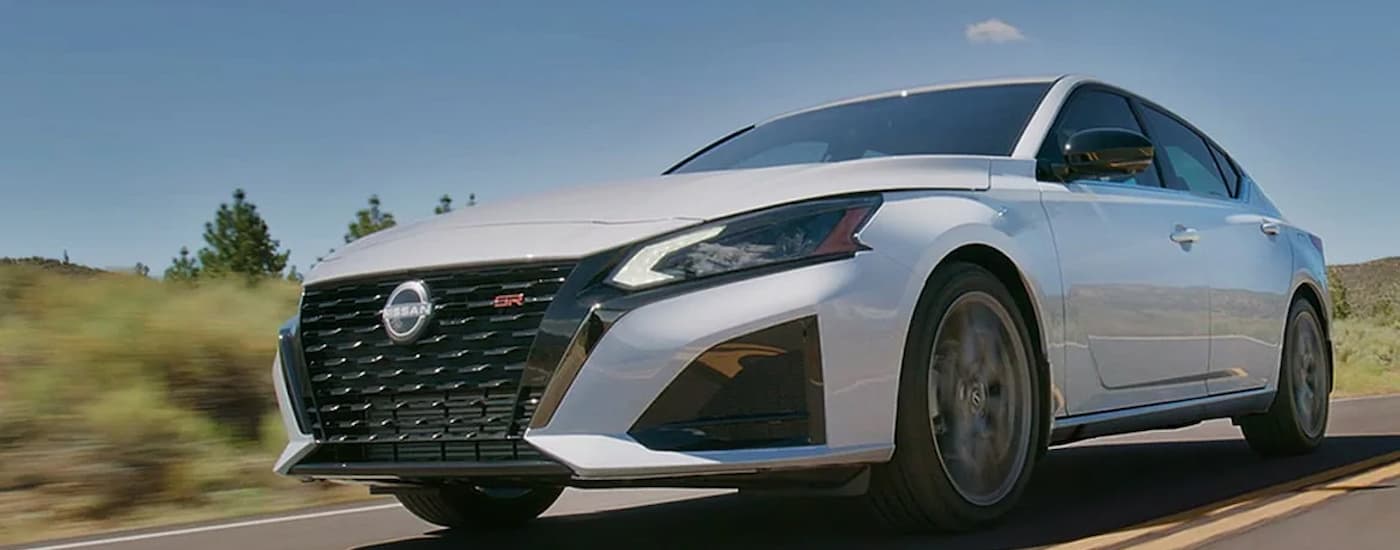 A silver 2024 Nissan Altima SE is shown driving on an open road after leaving a Caledonia Nissan dealer.