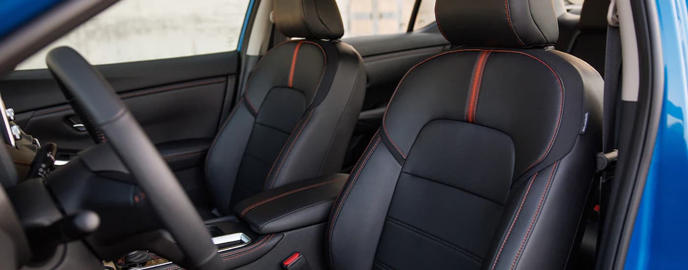 The black and red interior of a blue 2024 Nissan Sentra is shown.