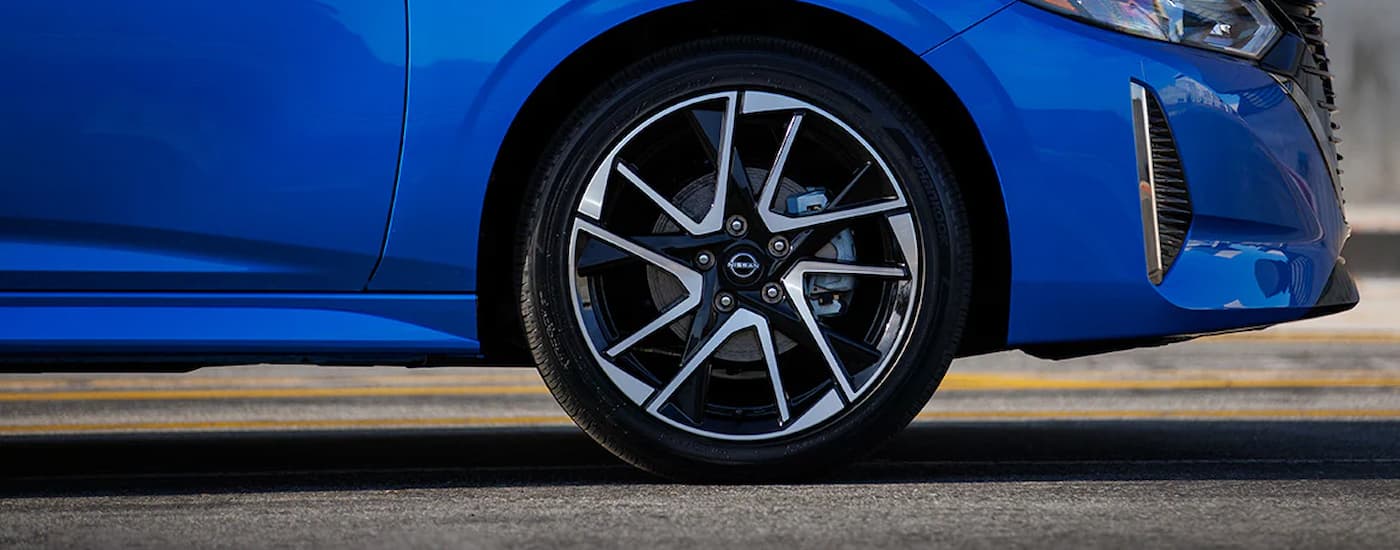 A close up of the passenger side tire on a blue 2024 Nissan Sentra SR is shown.