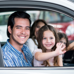 A happy family driving away in their new vehicle