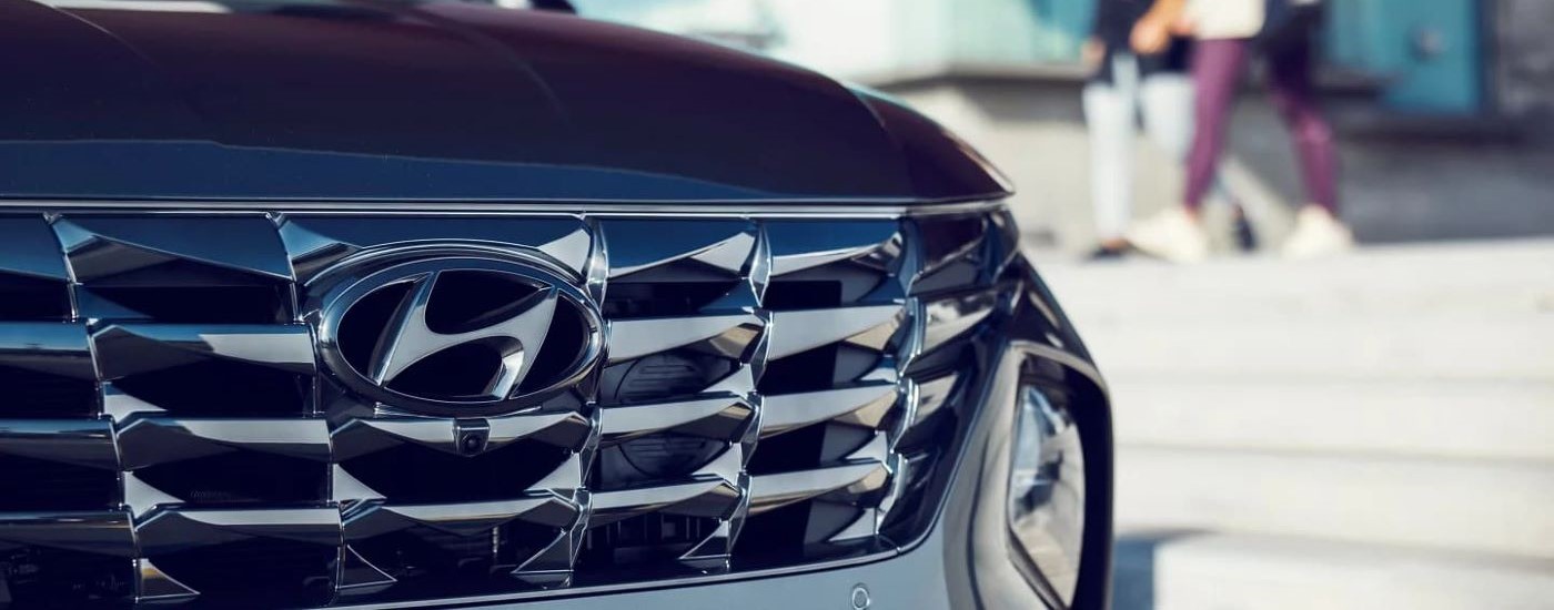 A close up of the grille on a black 2023 used Hyundai Tuscon for sale is shown.
