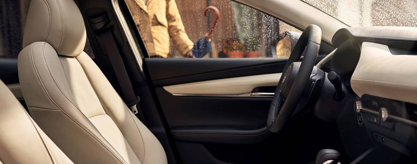 The beige and black interior is shown in a 2024 Mazda3.