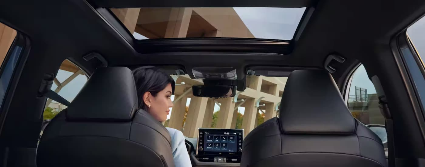 A woman is shown in the interior of a 2022 Toyota RAV4 after leaving a used Toyota dealer near Lincoln.