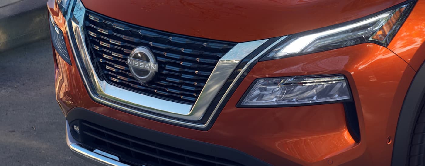 A close up of the grille on an orange 2023 Nissan Rogue is shown.