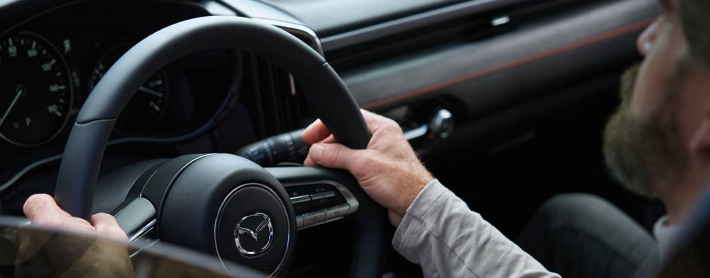 A person is shown driving a 2023 Mazda CX-50.