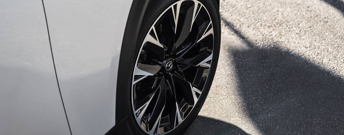 A close up shows a wheel on a white 2024 Mazda CX-90.