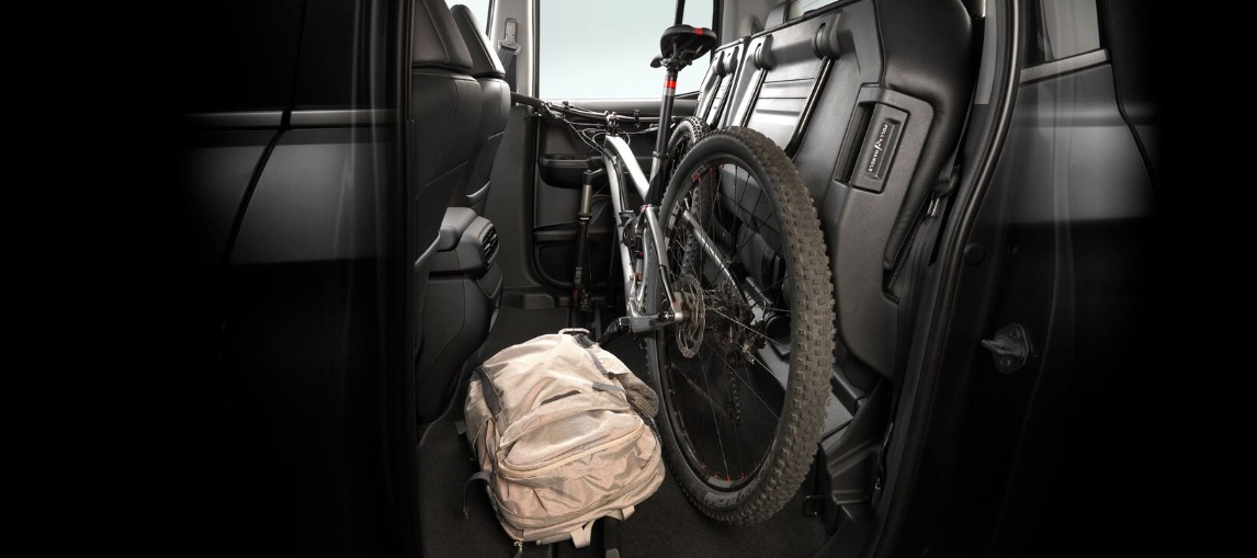 El Ridgeline te ofrece la posibilidad de cargar muchas cosas dentro de la cabina al permitirte abatir hacia arriba a los asientos de la segunda fila.