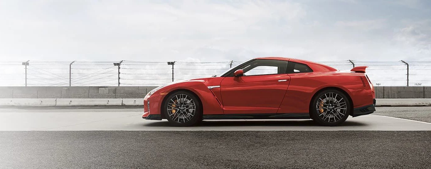 A red 2024 Nissan GT-R is shown from the side on a racetrack.