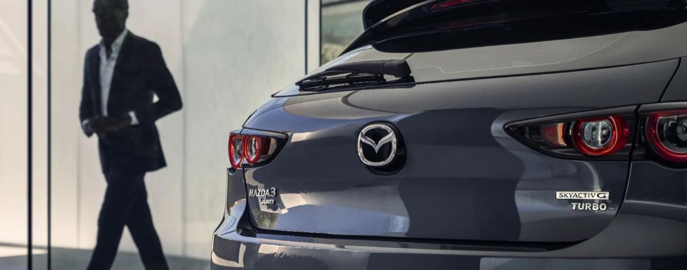 A close up shows the rear badging of a grey 2024 Mazda3.