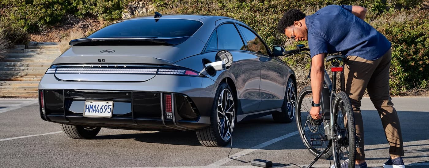  A man is shown inflating bike tires next to a silver 2024 Hyundai IONIQ 6.
