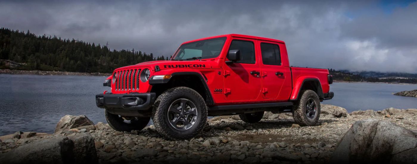 A red 2022 Jeep Gladiator Rubicon is shown near a lake.