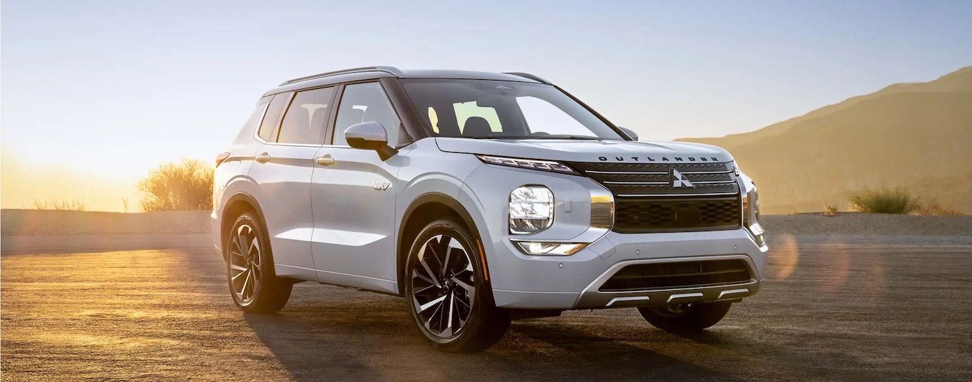 A white 2024 Mitsubishi Outlander PHEV for sale is shown front he front at an angle.