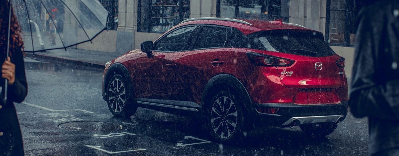 A red 2019 Mazda CX-3 is shown from the side on rainy day.