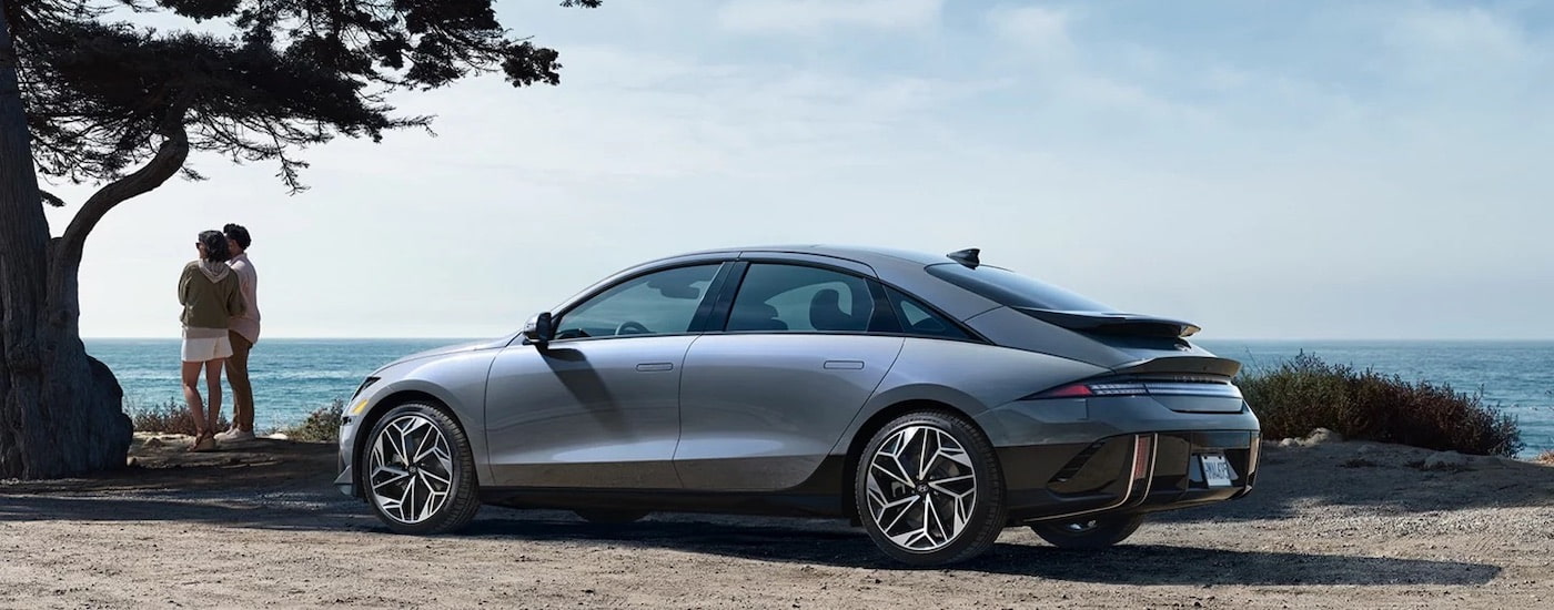 A grey 2024 IONIQ 6 is shown from the side while parked on the coast.