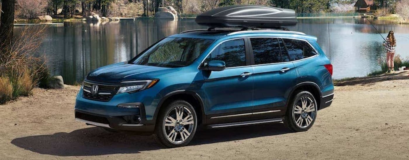 A blue 2021 Honda Pilot is shown from the front at an angle after leaving a dealer that has a Certified Pre-Owned Honda.