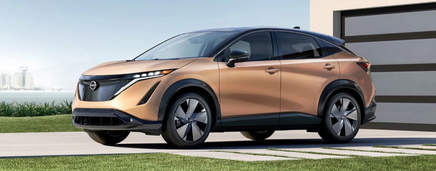 A bronze 2023 Nissan ARIYA for sale is shown parked on a driveway.