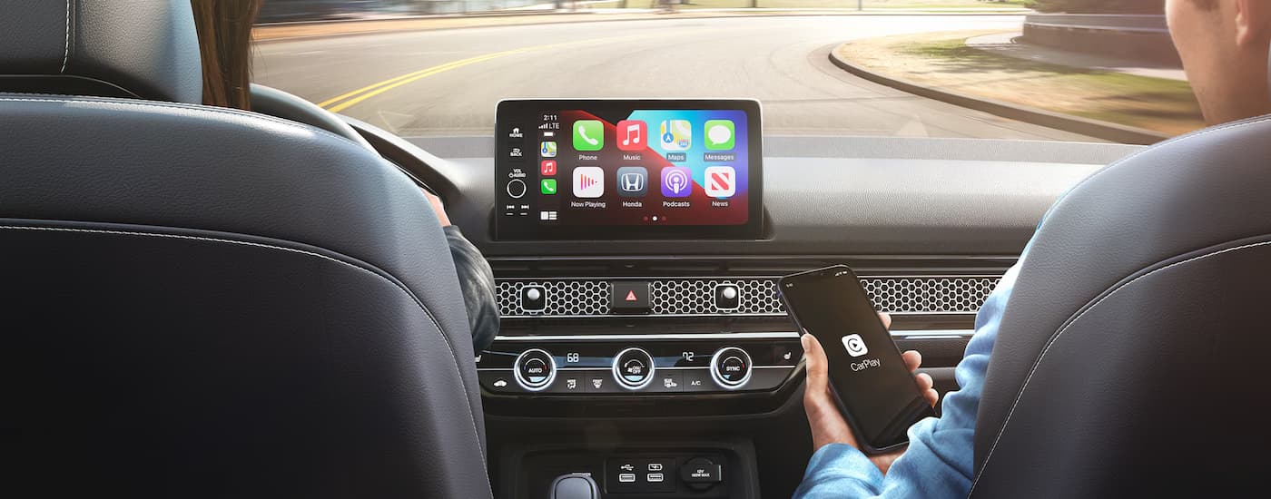 A person is shown using Apple Carplay in a 2024 Honda Civic Hatchback.