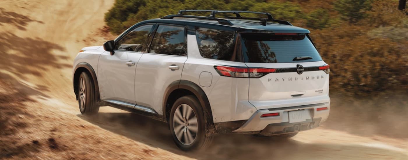 A white 2024 Nissan Pathfinder is shown from the rear at an angle.