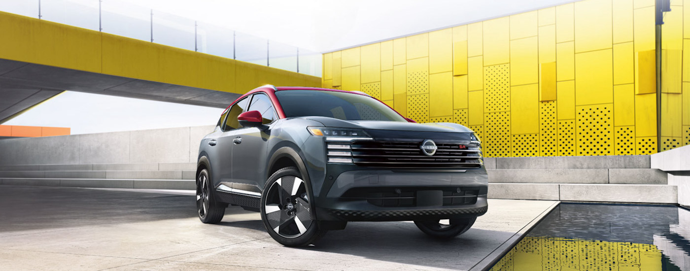 A grey 2025 Nissan Kick SR is shown from the front at an angle after leaving a dealer that has cars for sale.