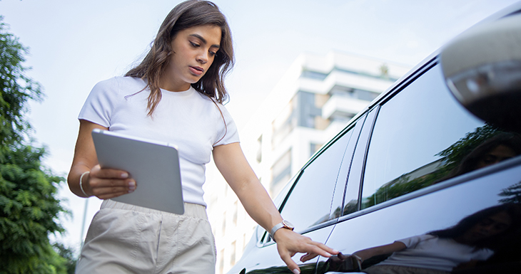 A women with a tablet picking up your trade-in vehicle