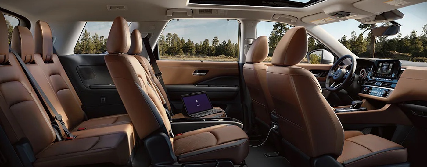 The brown interior of a 2024 Nissan Pathfinder is shown from the passenger side.