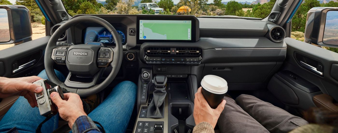 The black interior of a 2024 Toyota LandCruiser is shown from the center console.