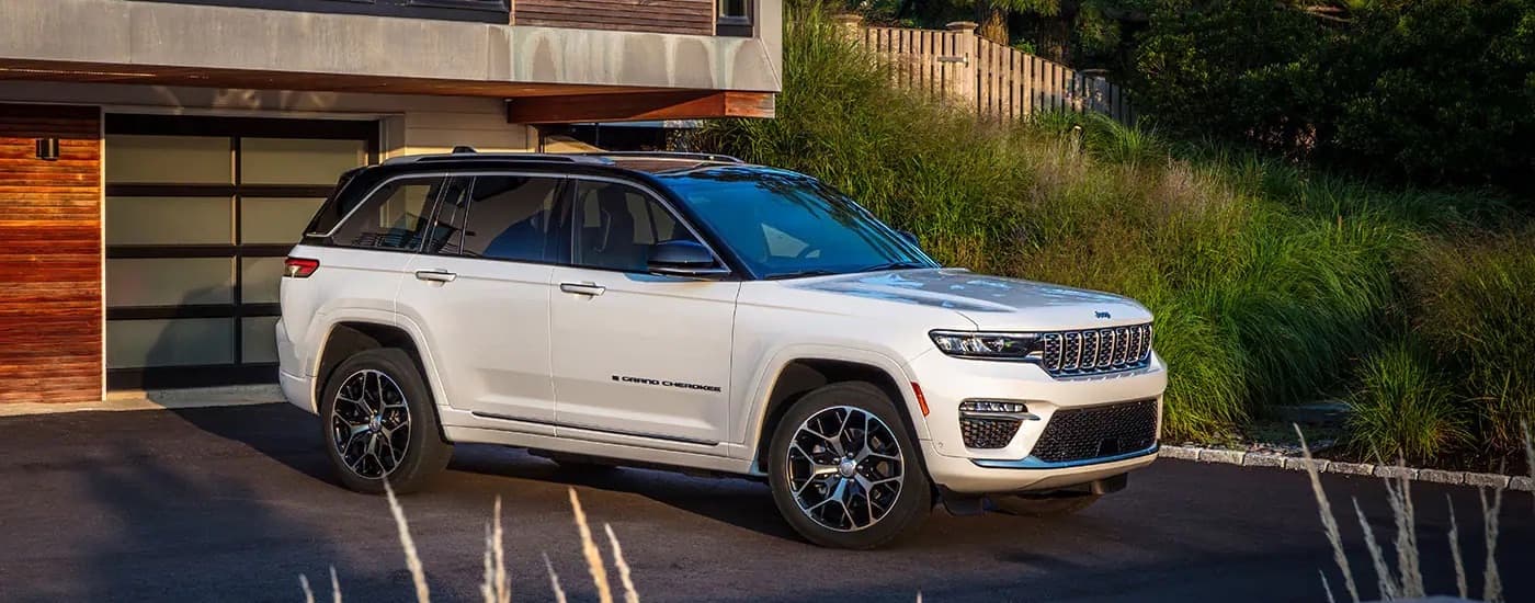 A white 2023 Jeep Grand Cherokee is shown from the side.