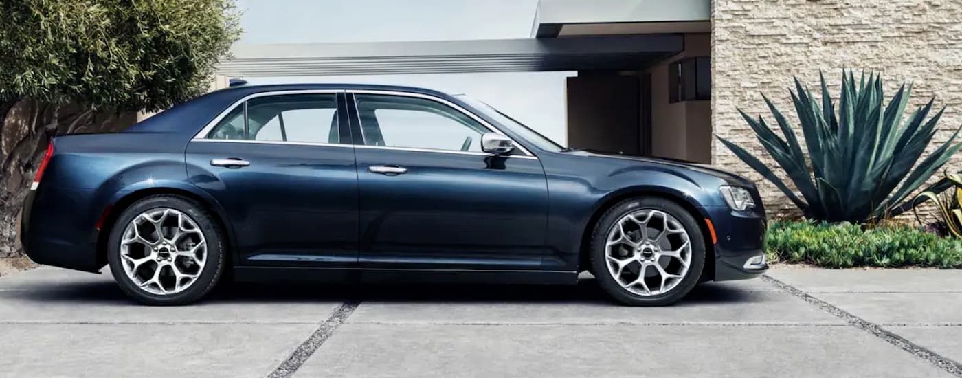 A blue 2020 Chrysler 300 is shown parked near a house.