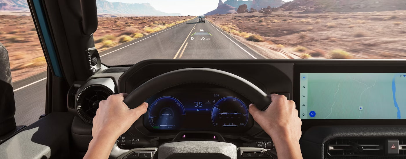 Driver's view of the Head-Up Display and infotainment screen in a 2024 Toyota Land Cruiser for sale.