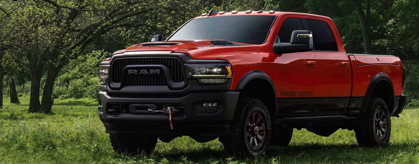 A red 2024 Ram 2500 Power Wagon parked in a grassy field.