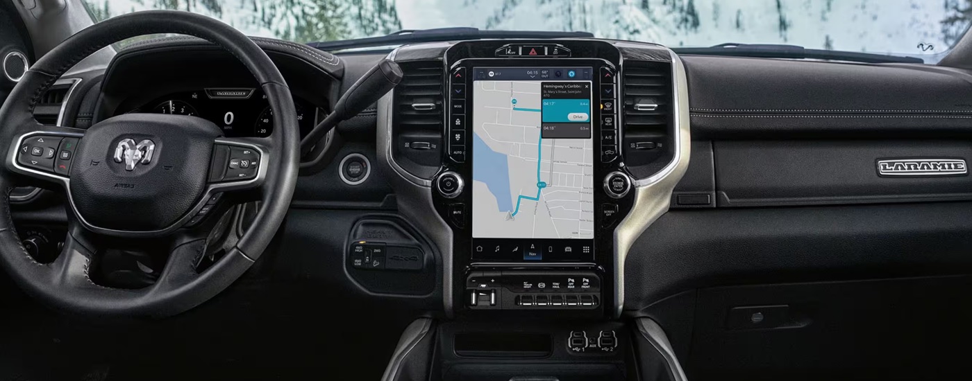 The steering wheel and infotainment screen in a 2024 Ram 2500 Laramie at a Ram dealer.
