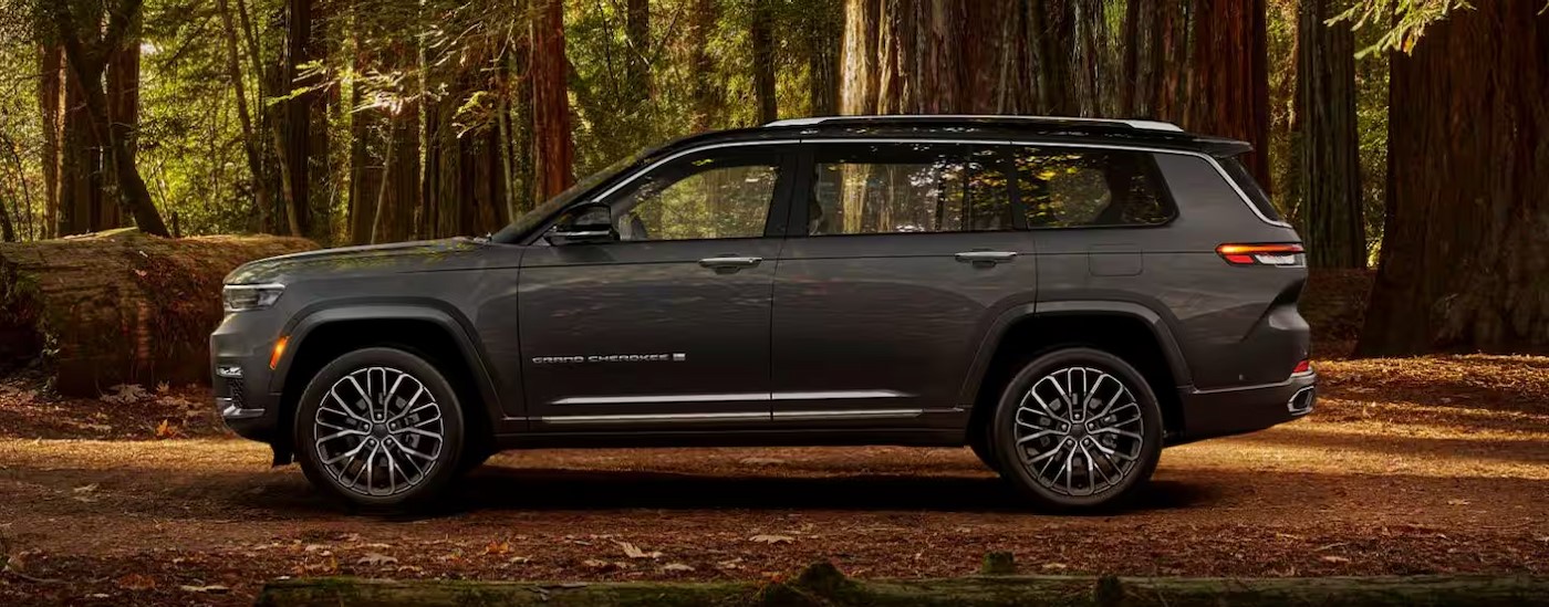 A gray 2024 Jeep Grand Cherokee L parked off-road after visiting a Jeep dealer.